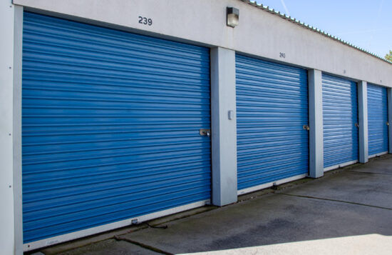 Service representative holding clipboard in front of blue storage containers